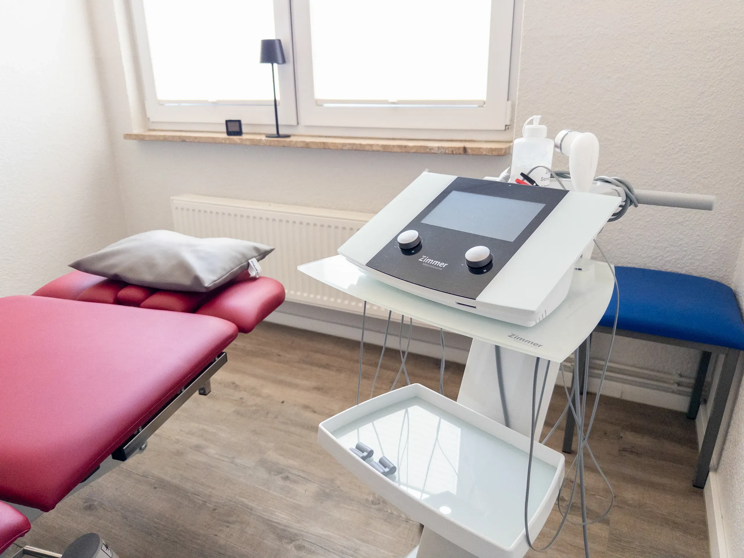 Behandlungsraum mit Elektrotherapiegerät auf Rollwagen