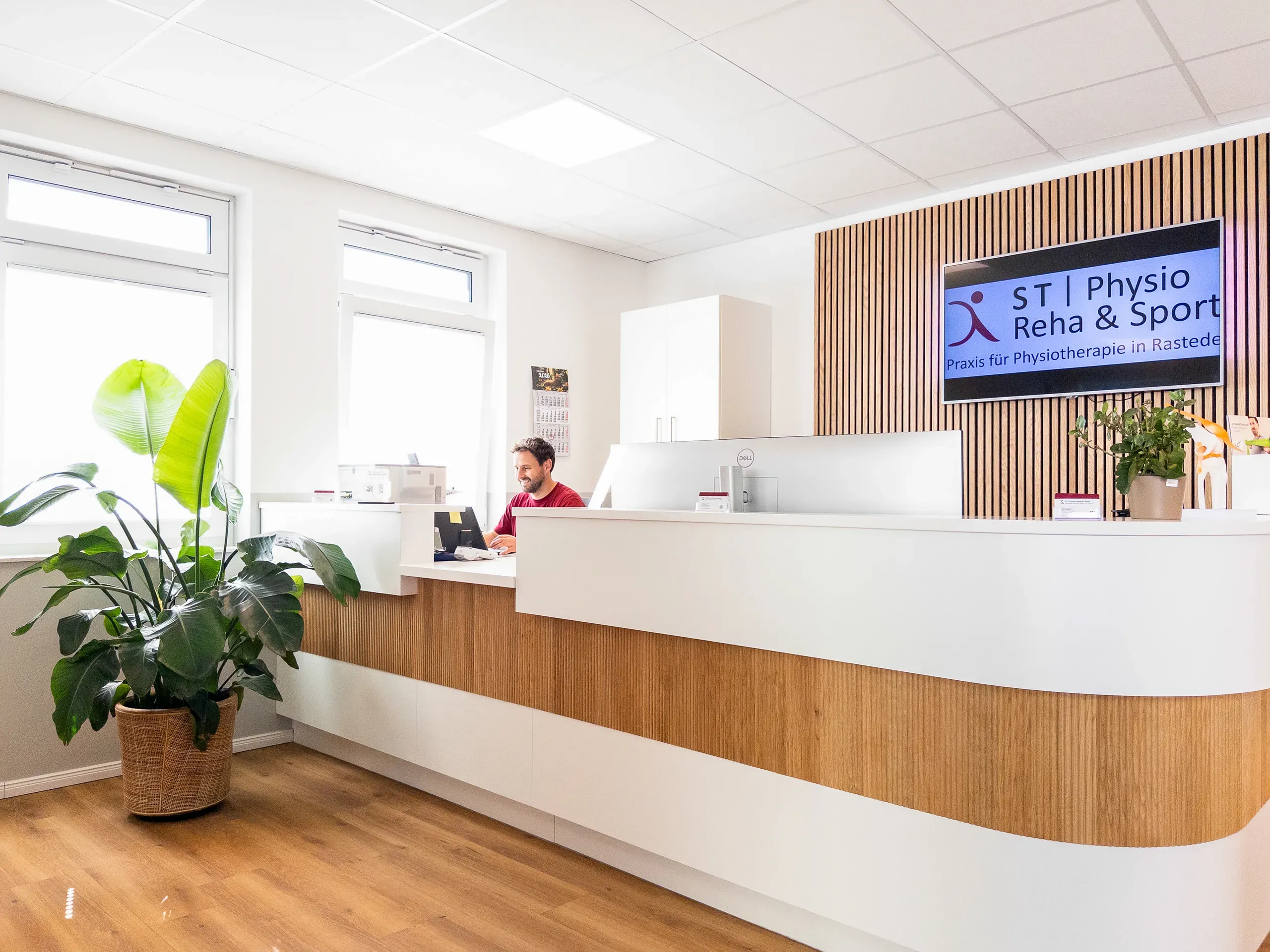 Empfangsbereich mit Mitarbeiter an der Rezeptionstheke