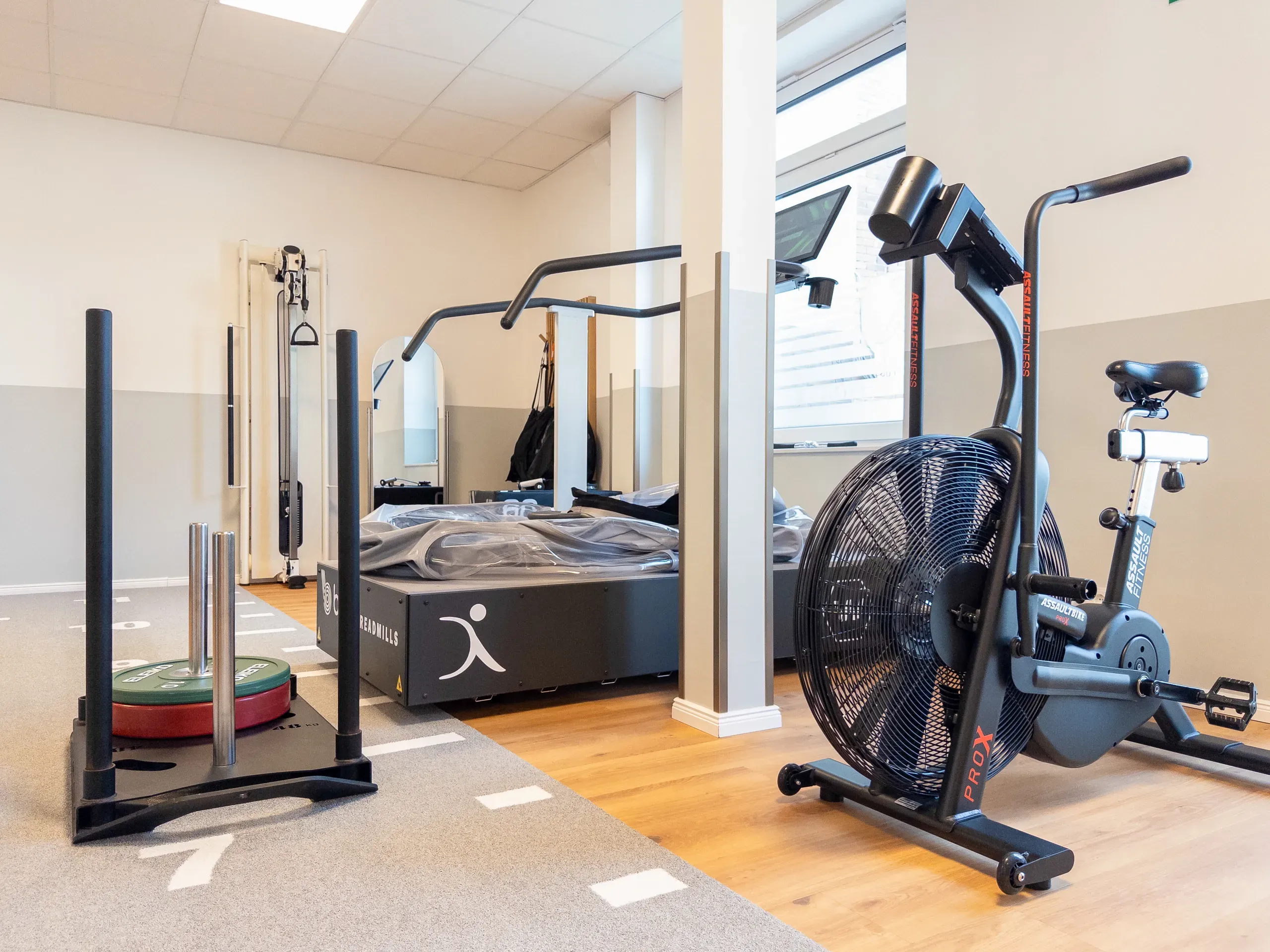 Fitnessraum mit Anti-Schwerkraft-Laufband, Airbike und Schlitten