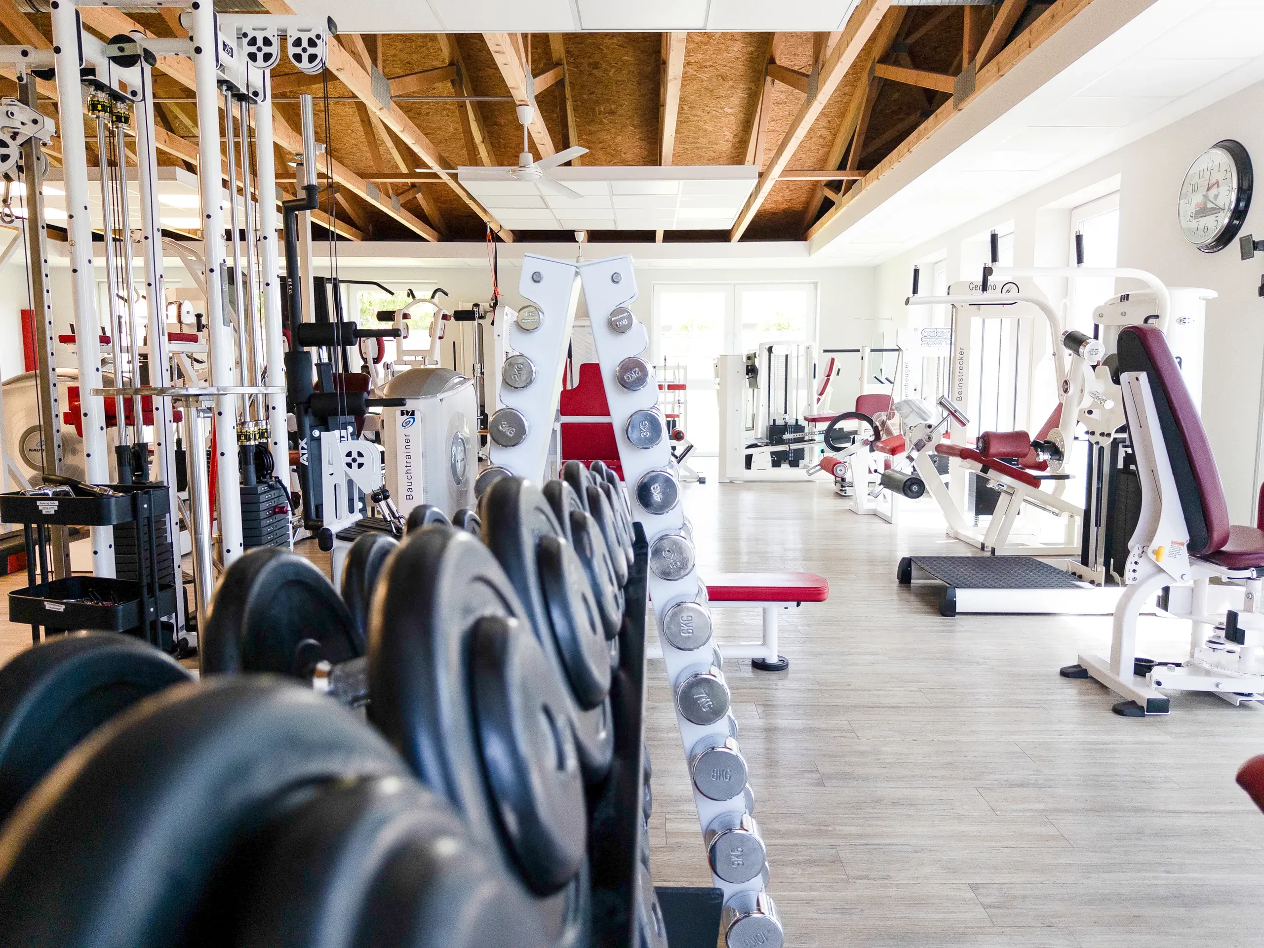 Leerer Fitnessraum mit Kurzhantelständern und Krafttrainingsgeräten
