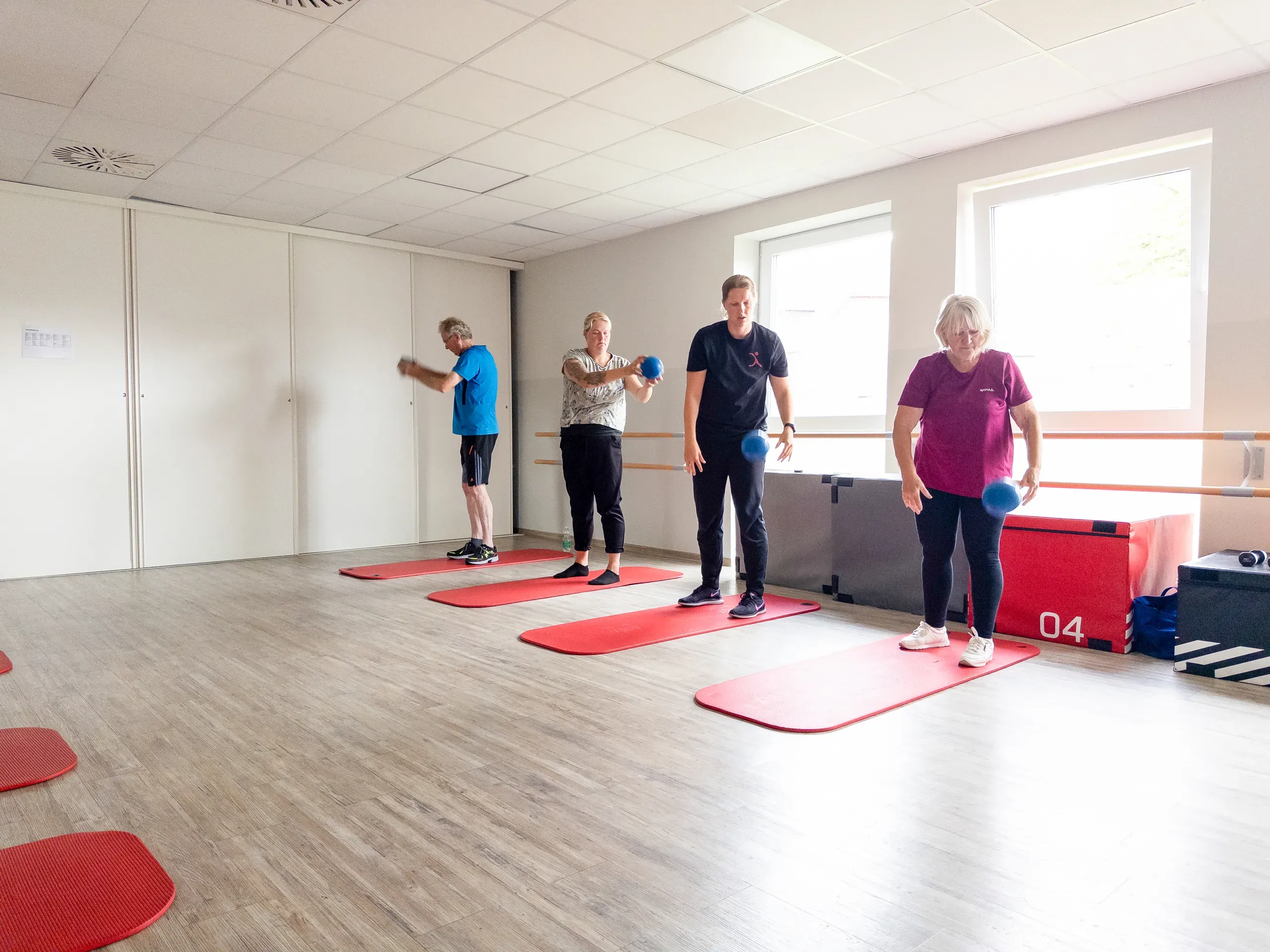 Kursleiter mit Teilnehmenden beim Gruppentraining im Kursraum