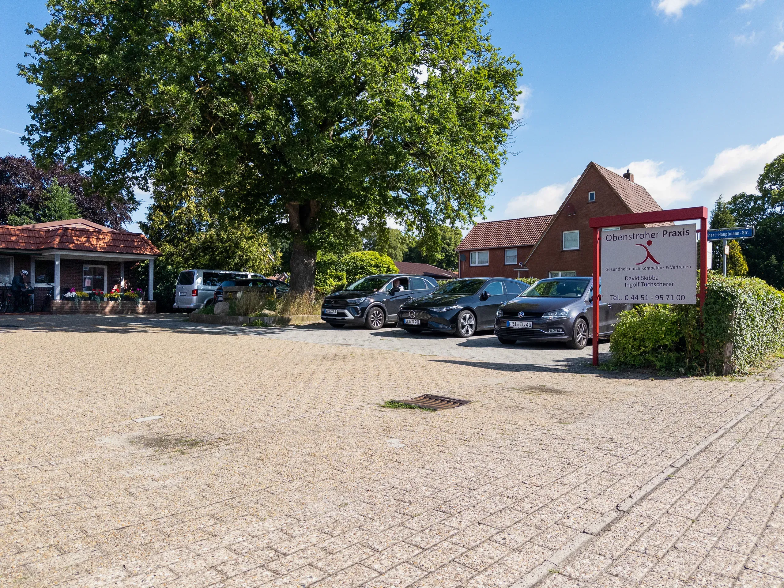 Außenansicht der Praxis Obenstrohe mit Parkplatz und Praxisschild
